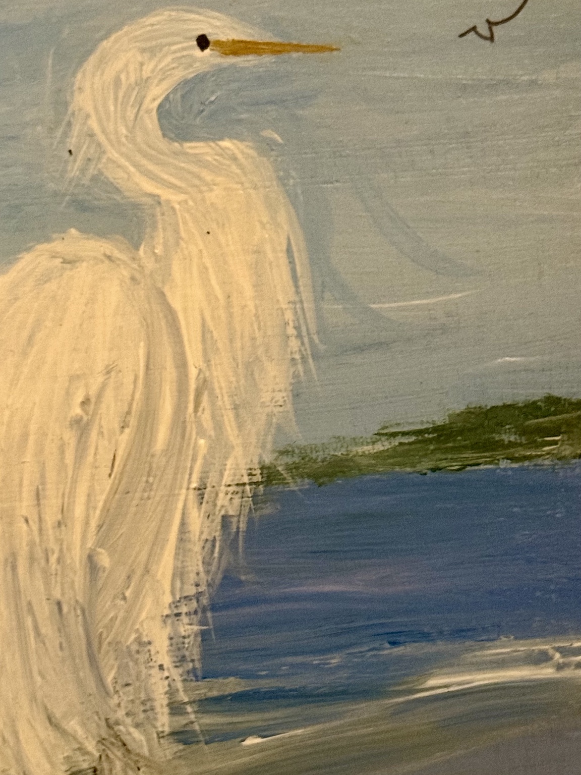 Close-up showing the white egret and textured shoreline