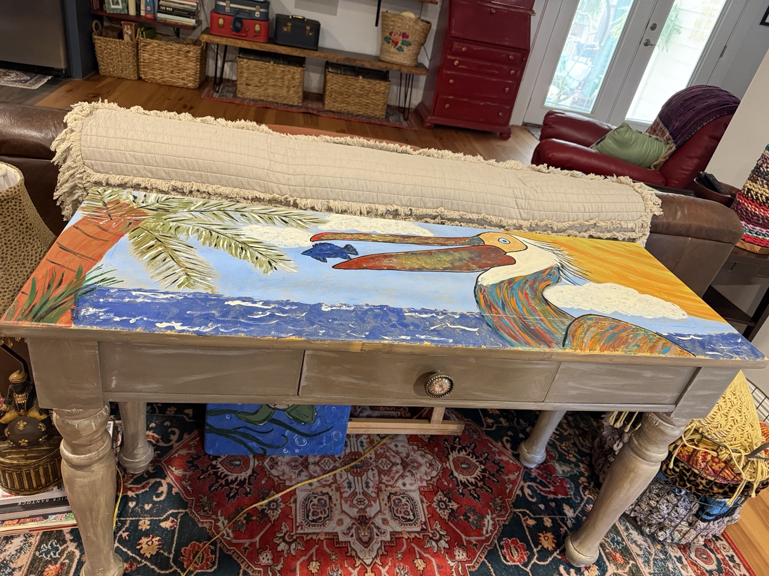 Painted pelican beach scene on a wooden console table
