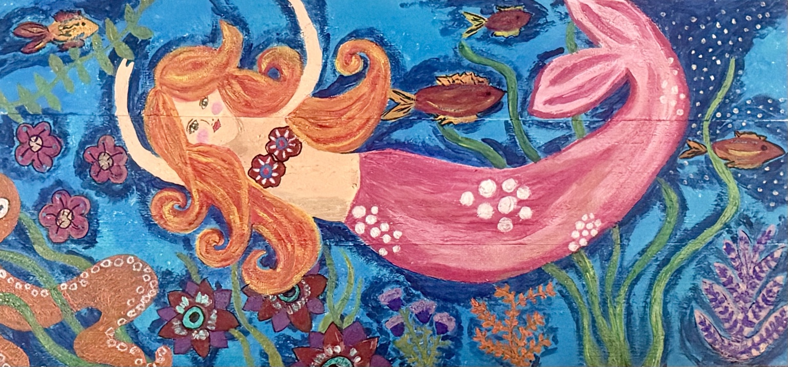 Red-haired mermaid swimming among fish and flowers