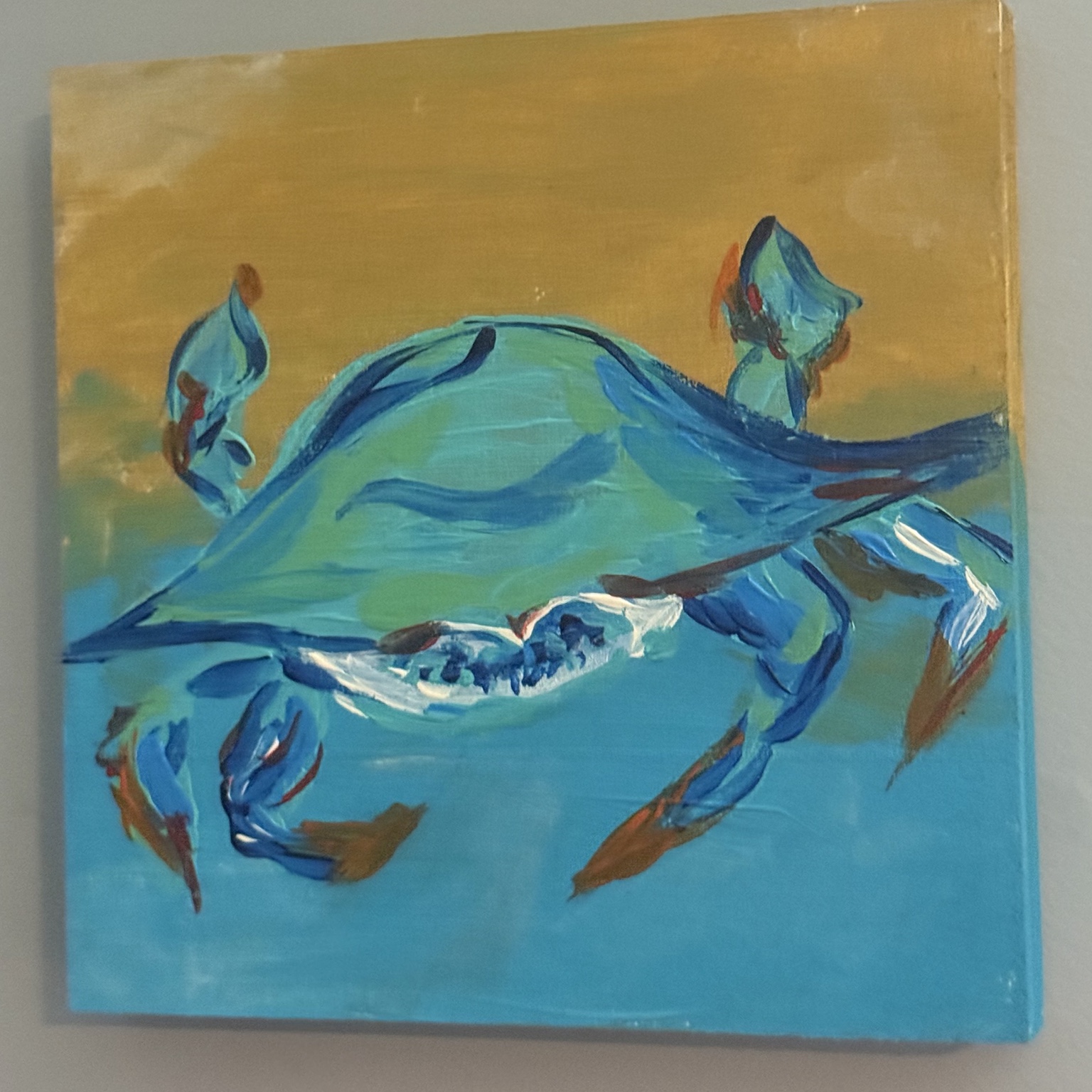Painting of a blue crab against golden and turquoise colors