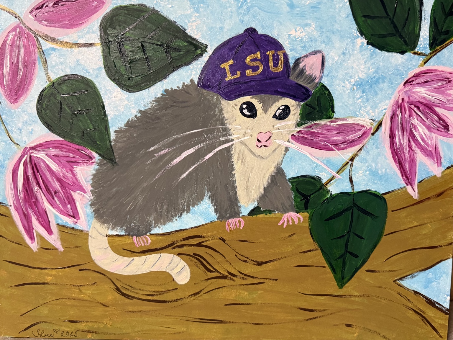 Opossum wearing a purple LSU cap among pink blossoms