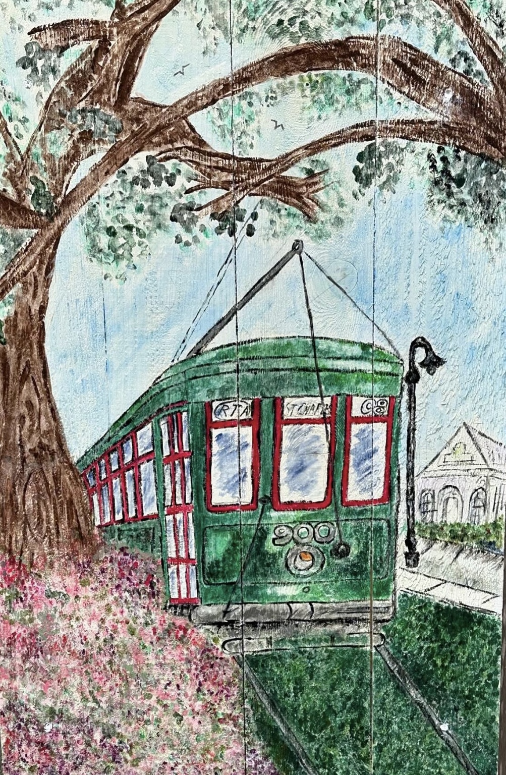 Green New Orleans streetcar beneath an oak tree