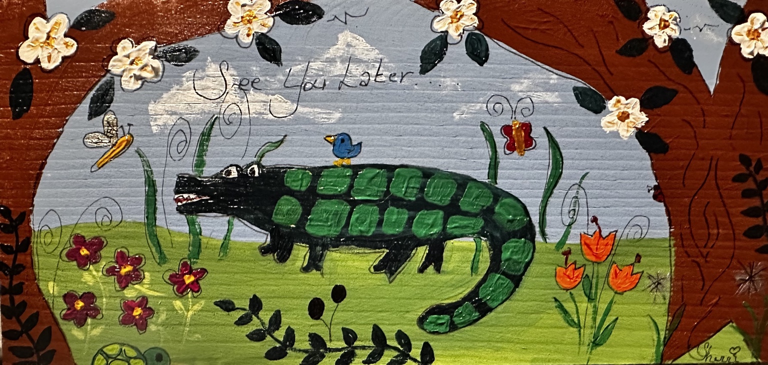 Alligator beneath flowering branches with a bird on its back