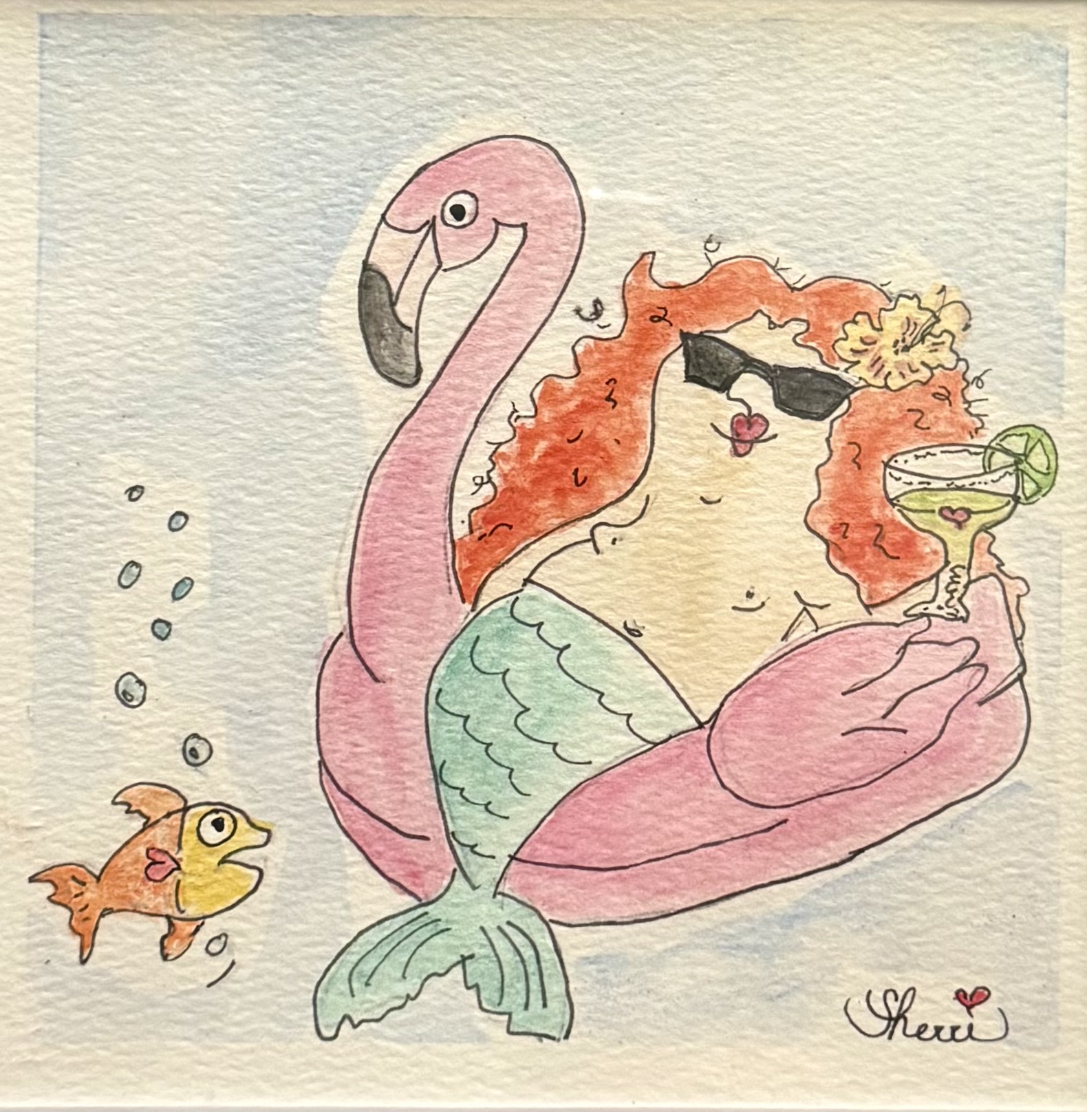 Mabel the mermaid relaxing on a pink flamingo float with Nugget nearby