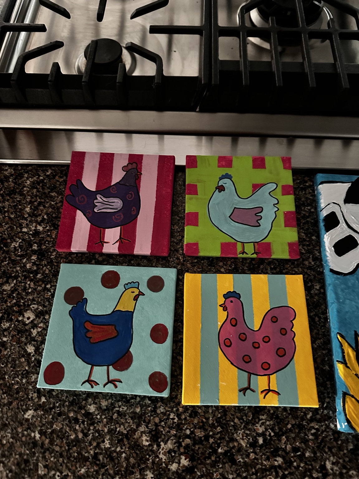 Four small colorful chicken paintings arranged together